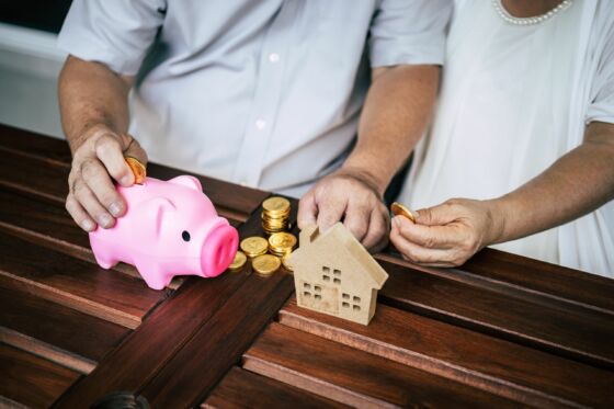 Elderly Couples talking about real estate finance with piggy bank